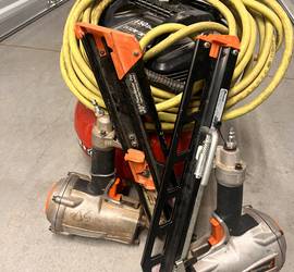 Two framing nails a hose and a pancake compressor