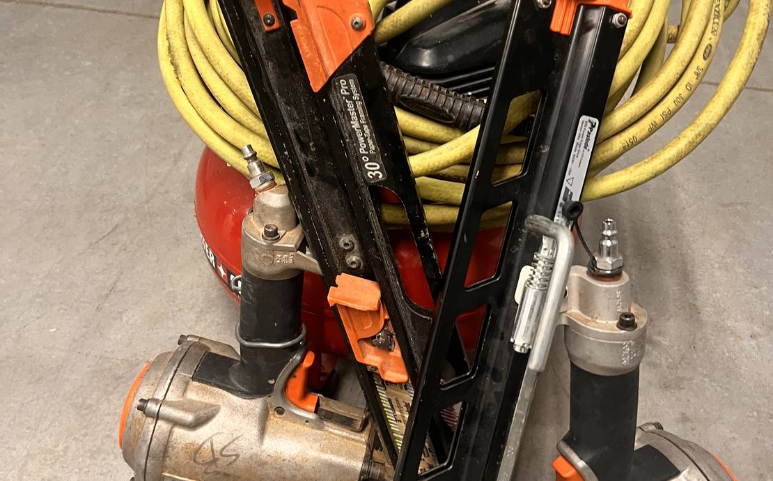 Two framing nails a hose and a pancake compressor