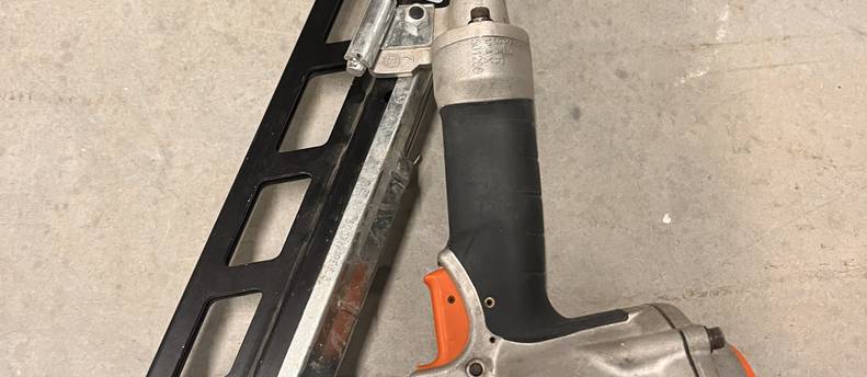 Two framing nails a hose and a pancake compressor