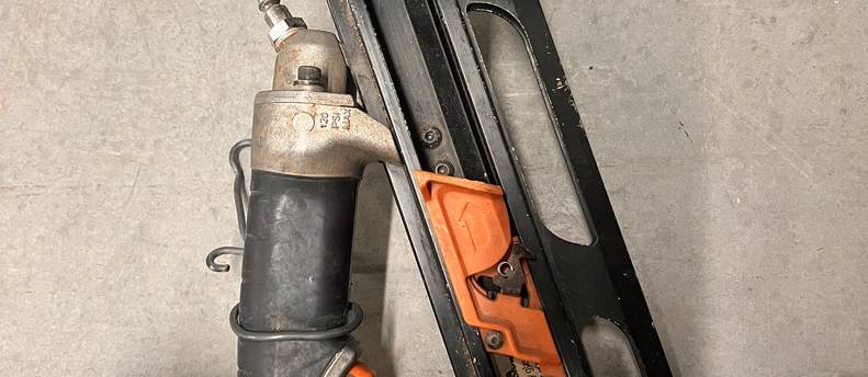 Two framing nails a hose and a pancake compressor