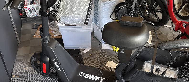 SWFT electric scooter with a seat and basket